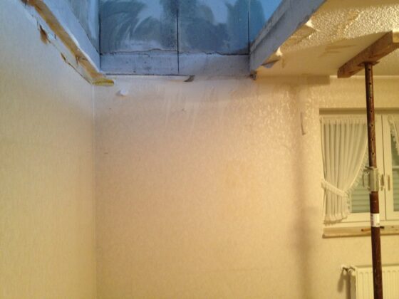 Unvollendete Wand und Decke in einem Innenraum mit sichtbaren Renovierungsarbeiten.