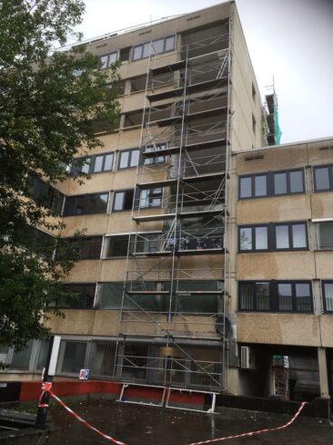 Ein mehrstöckiges Gebäude mit einem Gerüst an der Fassade für Renovierungsarbeiten.
