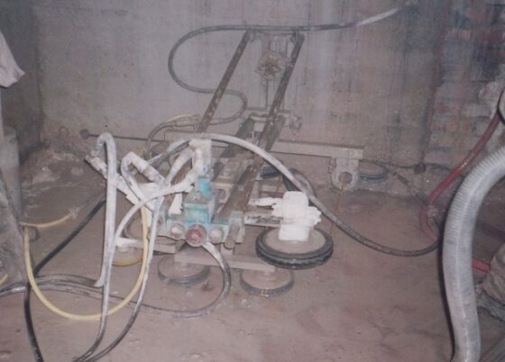 Seilsaege mit mehreren Rollen und Schläuchen in einem Innenraum auf dem Boden.